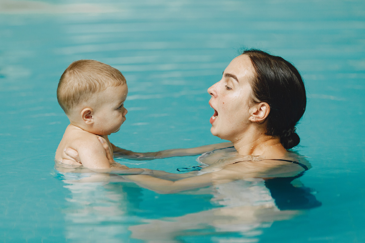 Acquaticita neonatale - neonato che gioca con la mamma in acqua