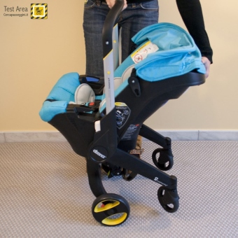 Simple Parenting Doona Infant Car Seat - Fase di chiusura - mossa 1c - Accompagnare verso l'interno con il piede le ruote posteriori, che scivoleranno nella posizione di chiusura