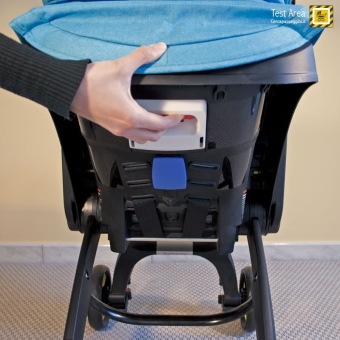 Simple Parenting Doona Infant Car Seat - Fase di chiusura - mossa 1b - Premere la leva posta sul retro dello schienale della seduta